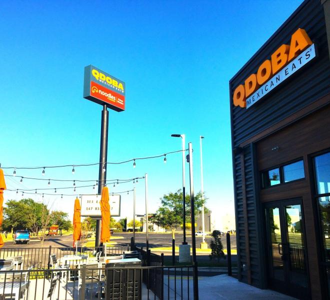 Photograph of the new QDOBA Mexican Eats Location exterior, outdoor patio, and sign in Delavan, WI.